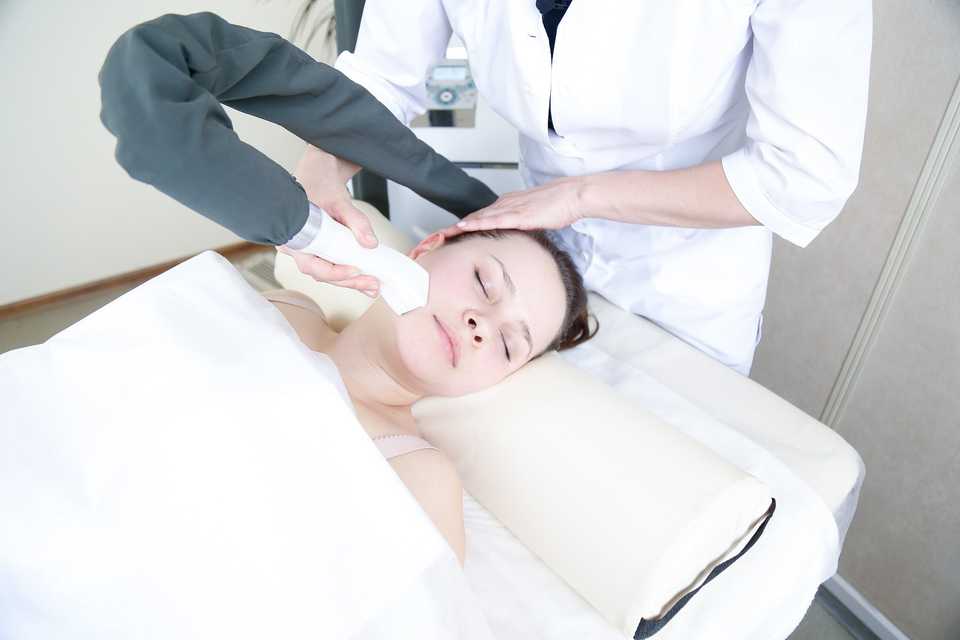 Врач проводит процедуру LPG-массажа лица 